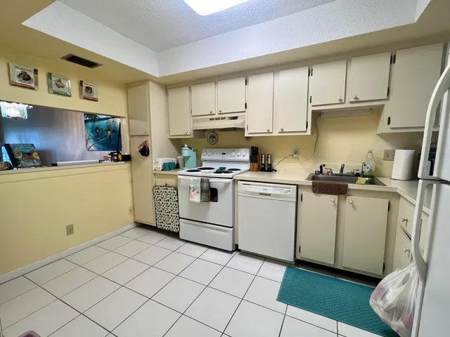 a kitchen with cabinets a sink and white appliances