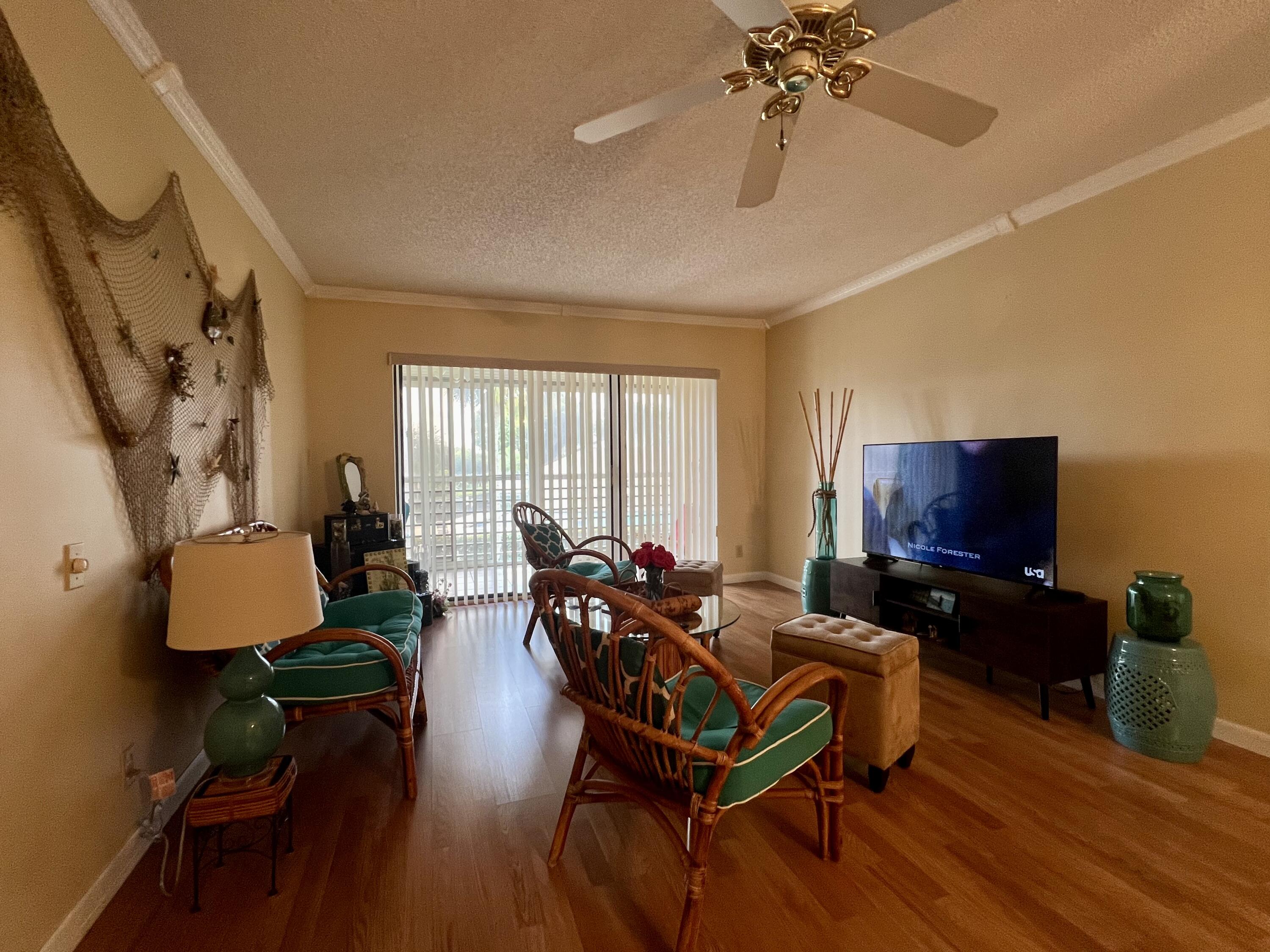 3154 Via Poinciana, Unit 214 Lake Worth, FL 33467 - Photo 7 of 23 a living room with furniture and a flat screen tv
