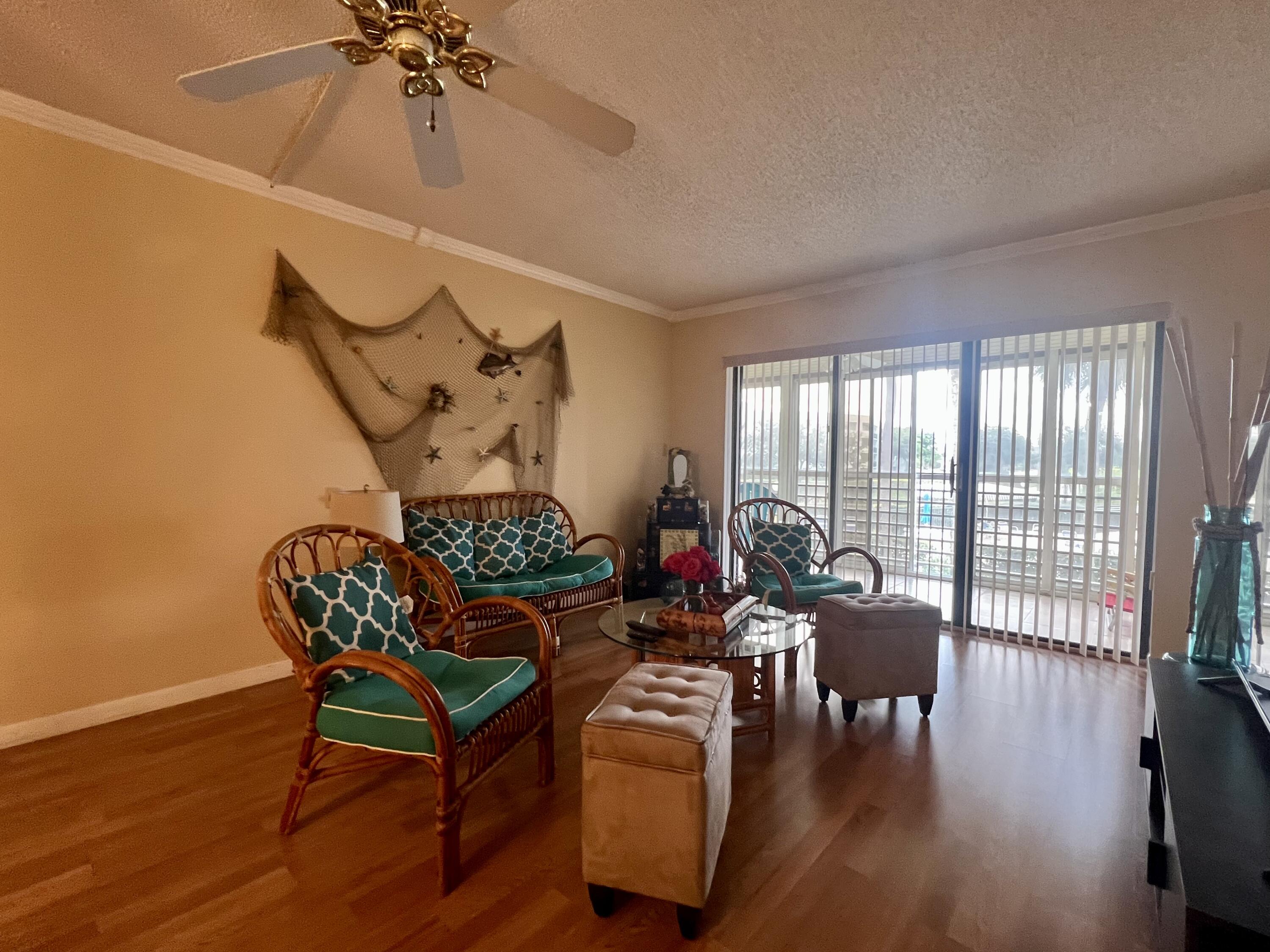 3154 Via Poinciana, Unit 214 Lake Worth, FL 33467 - Photo 9 of 23 a living room with furniture and wooden floor