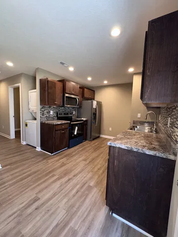 a kitchen with stainless steel appliances granite countertop a stove a sink and a refrigerator