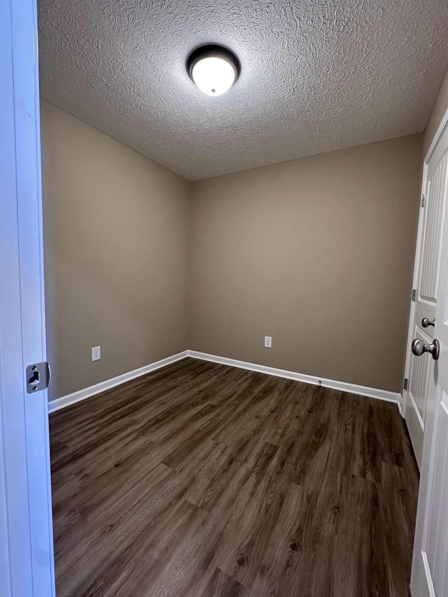 517 Weaver Street, Unit 4 Tullahoma, TN 37388 - Photo 5 of 22 an empty room with wooden floor and windows