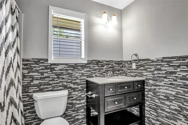 a bathroom with a toilet a sink and a mirror