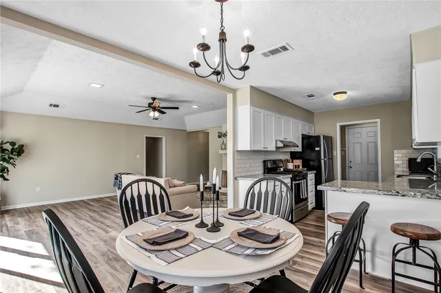 a view of a dining room with furniture a chandelier and wooden floor