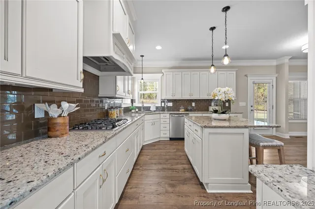 a view of a livingroom with wooden floor a fireplace and windows
