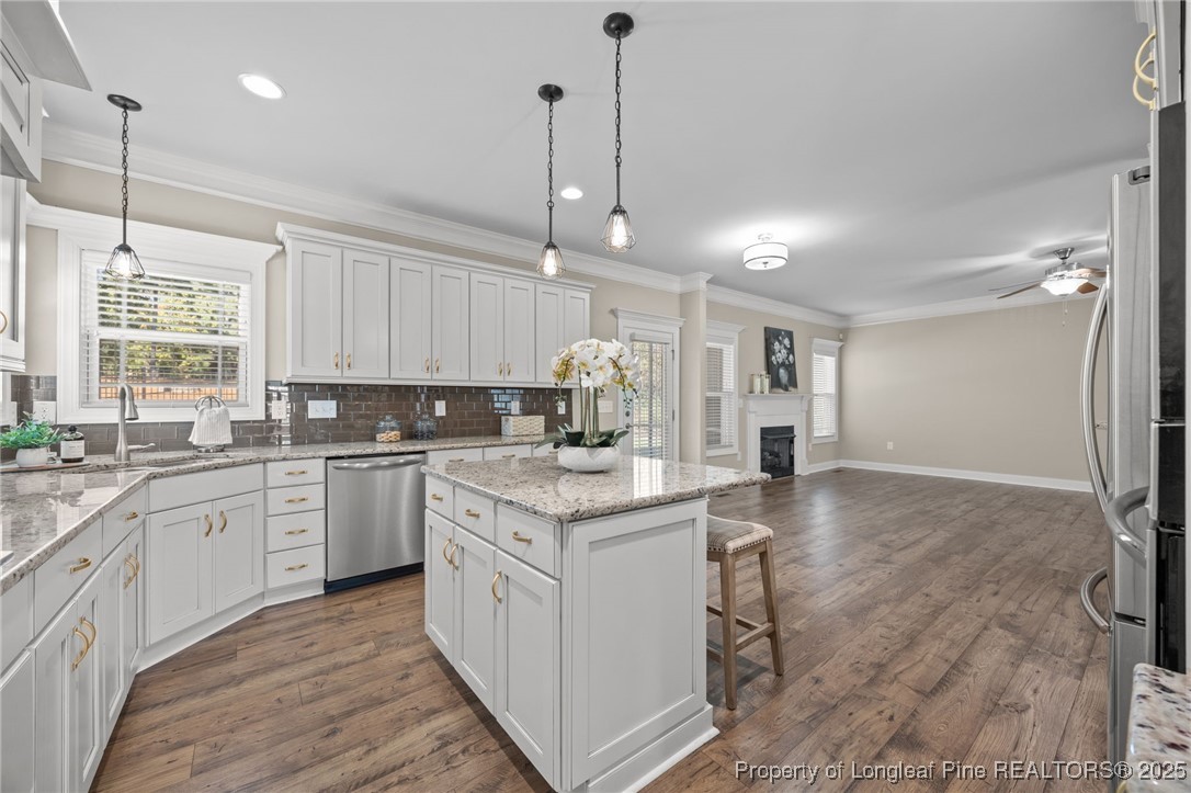 2904 Hampton Ridge Road Fayetteville, NC 28311 - Photo 15 of 50 a kitchen with a stove a sink dishwasher a kitchen island with wooden cabinets and floor