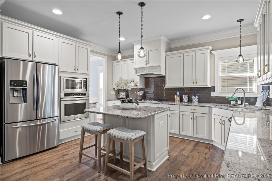 2904 Hampton Ridge Road Fayetteville, NC 28311 - Photo 18 of 50 a kitchen with stainless steel appliances granite countertop a sink a stove a refrigerator cabinets and chairs