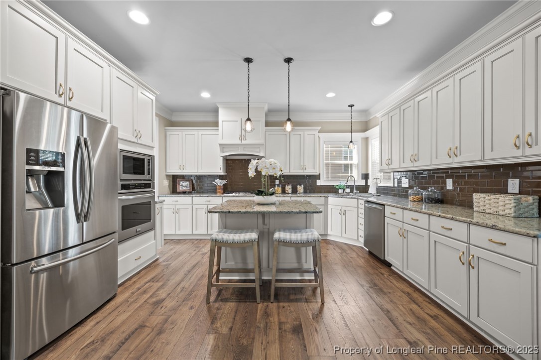 2904 Hampton Ridge Road Fayetteville, NC 28311 - Photo 19 of 50 a kitchen with stainless steel appliances granite countertop a refrigerator a stove top oven a sink dishwasher and white cabinets with wooden floor