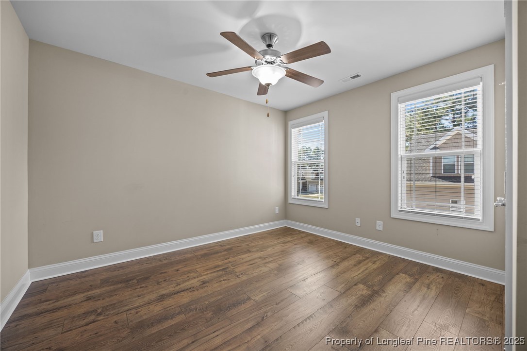 2904 Hampton Ridge Road Fayetteville, NC 28311 - Photo 37 of 50 an empty room with wooden floor fan and windows