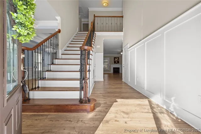 a view of an empty room with wooden floor and windows