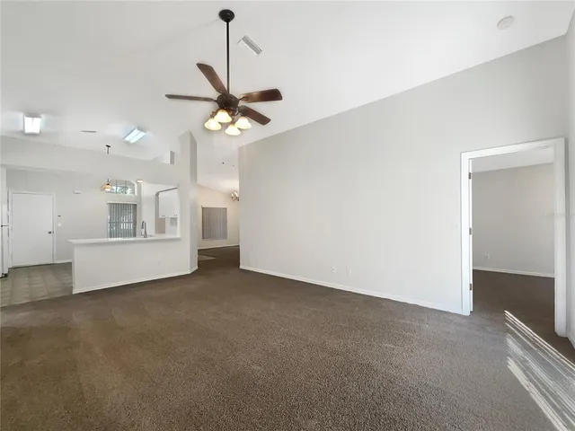 a view of an empty room with a kitchen