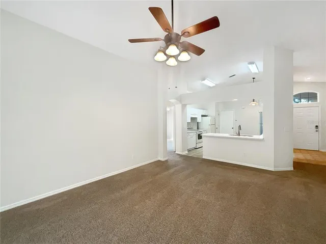 a view of a kitchen with a sink cabinetry a chandelier fan and a kitchen view