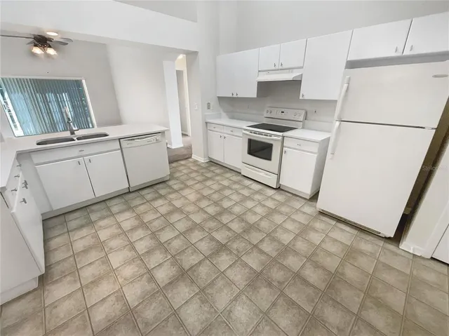 a kitchen with a stove a sink and a refrigerator