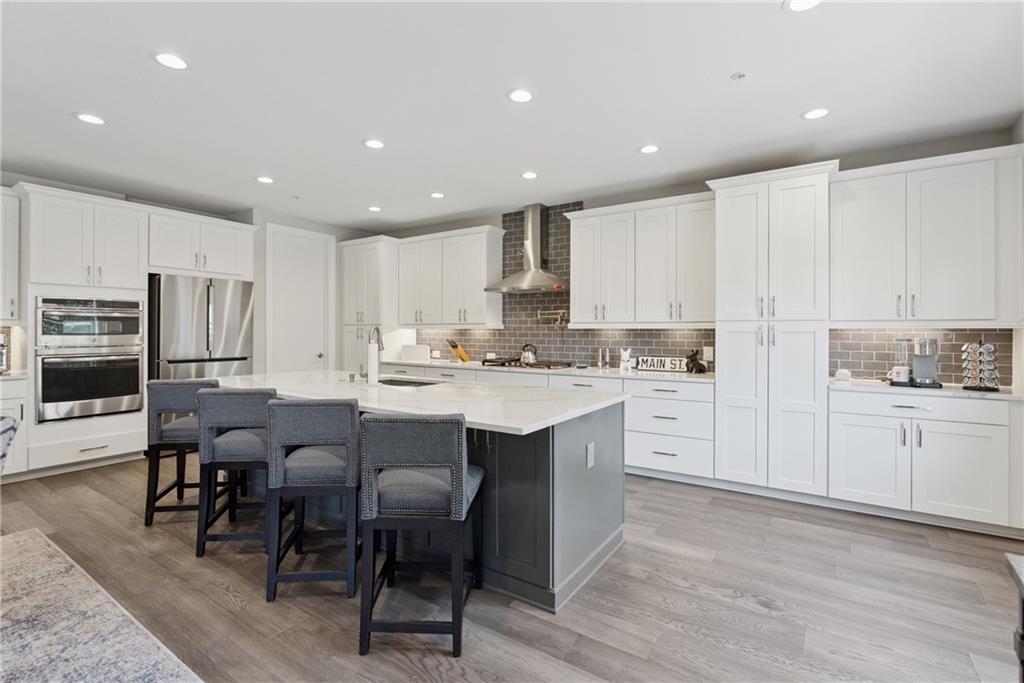 8255 Main Street, Unit 2 Woodstock, GA 30188 - Photo 15 of 46 a kitchen with white cabinets stainless steel appliances and kitchen island