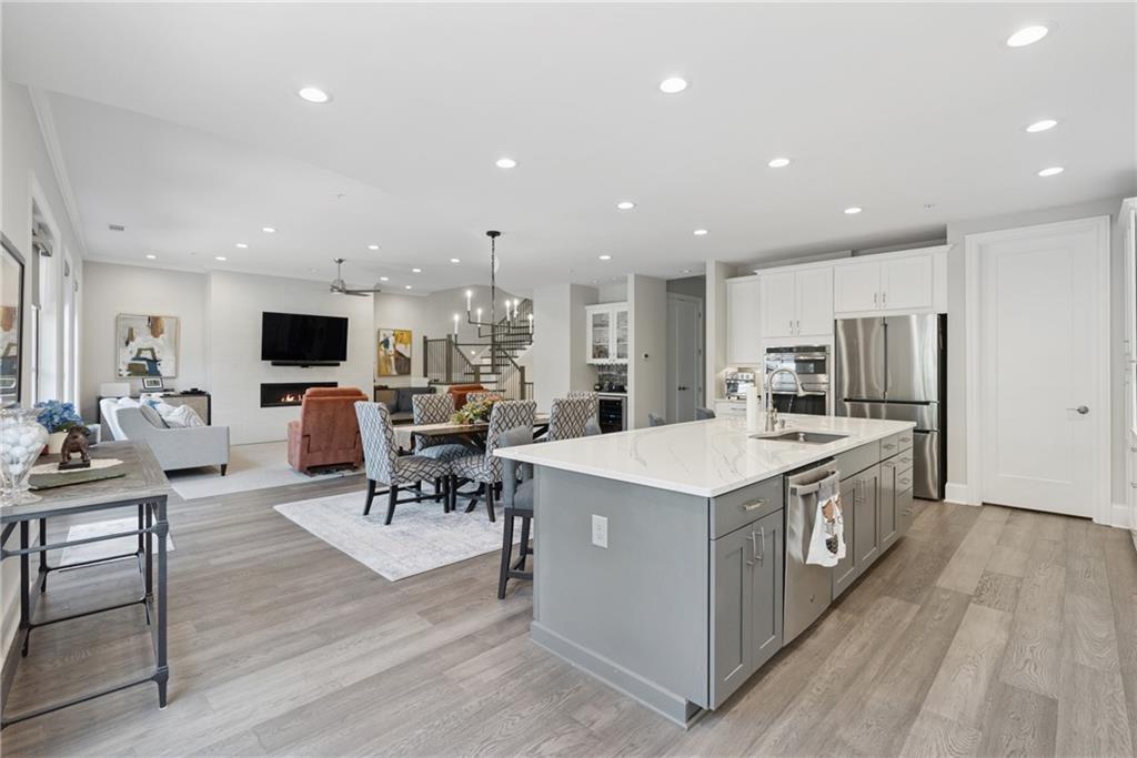 8255 Main Street, Unit 2 Woodstock, GA 30188 - Photo 16 of 46 a kitchen with stainless steel appliances a stove a sink a oven a dining table and chairs