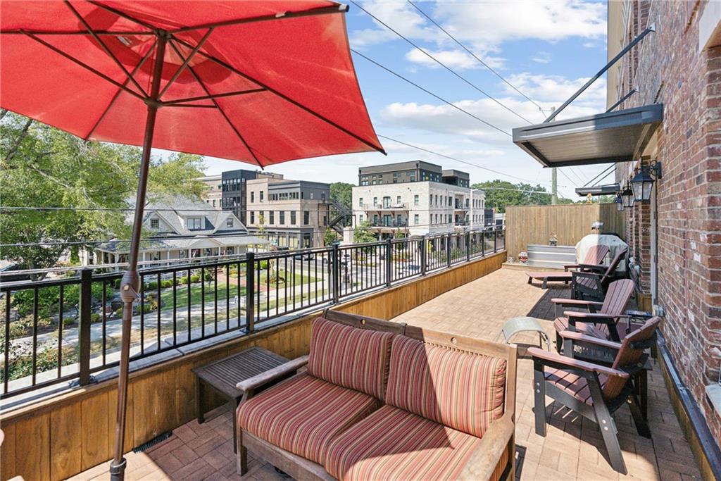 8255 Main Street, Unit 2 Woodstock, GA 30188 - Photo 20 of 46 a view of a balcony with furniture and umbrella