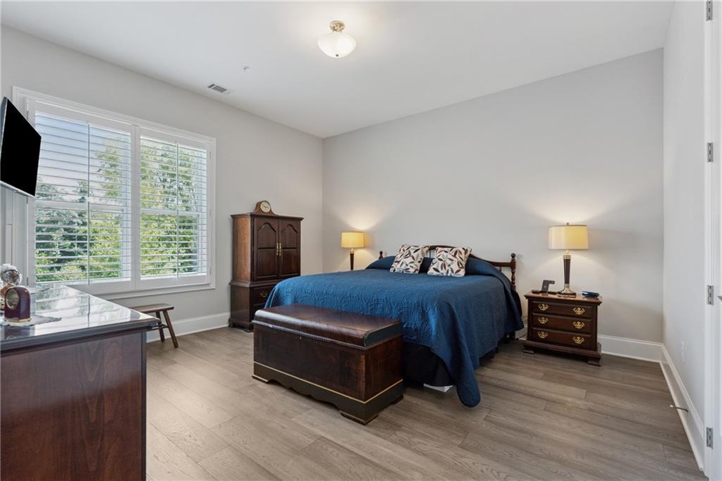 8255 Main Street, Unit 2 Woodstock, GA 30188 - Photo 21 of 46 a spacious bedroom with a bed and wooden floor