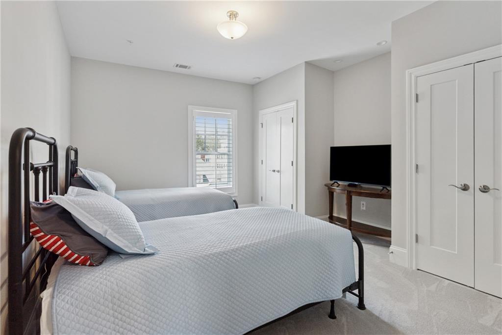 8255 Main Street, Unit 2 Woodstock, GA 30188 - Photo 24 of 46 a bedroom with a bed and a flat screen tv