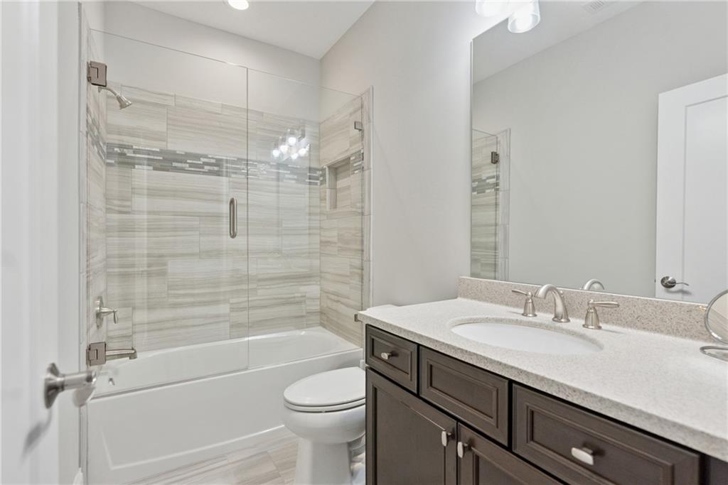 8255 Main Street, Unit 2 Woodstock, GA 30188 - Photo 25 of 46 a bathroom with a granite countertop sink a toilet and shower