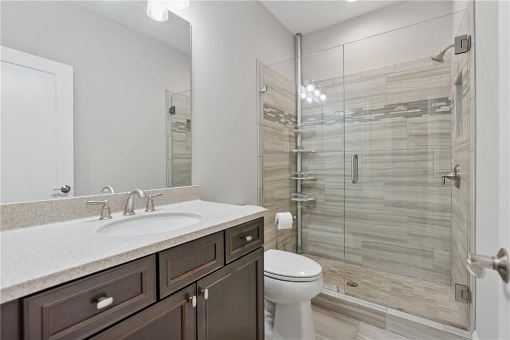 8255 Main Street, Unit 2 Woodstock, GA 30188 - Photo 27 of 46 a bathroom with a sink a toilet and shower