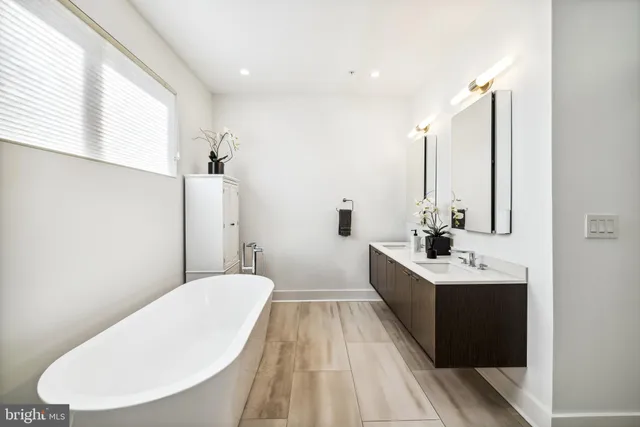 a bathroom with a double vanity sink toilet and mirror