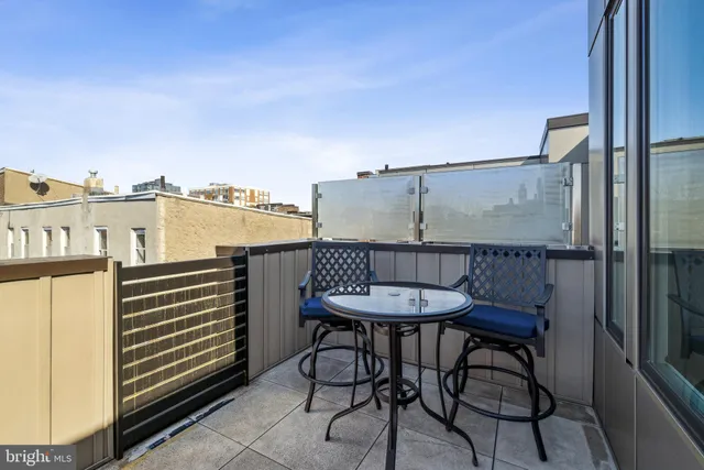 a view of a balcony with a chair and iron fence