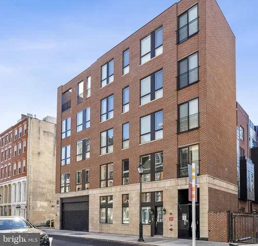 a living room with couches and a dining table with kitchen view