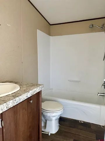 a bathroom with a granite countertop bathtub shower sink and toilet