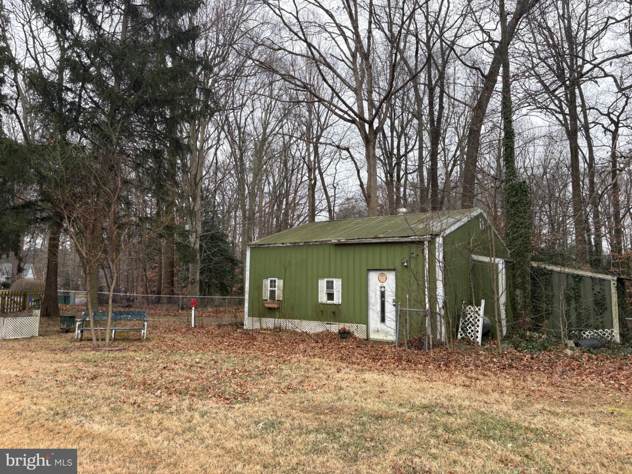 152 Pine Bluff Road Felton, DE 19943 - Photo 5 of 16 Charming green shed nestled in nature's embrace.