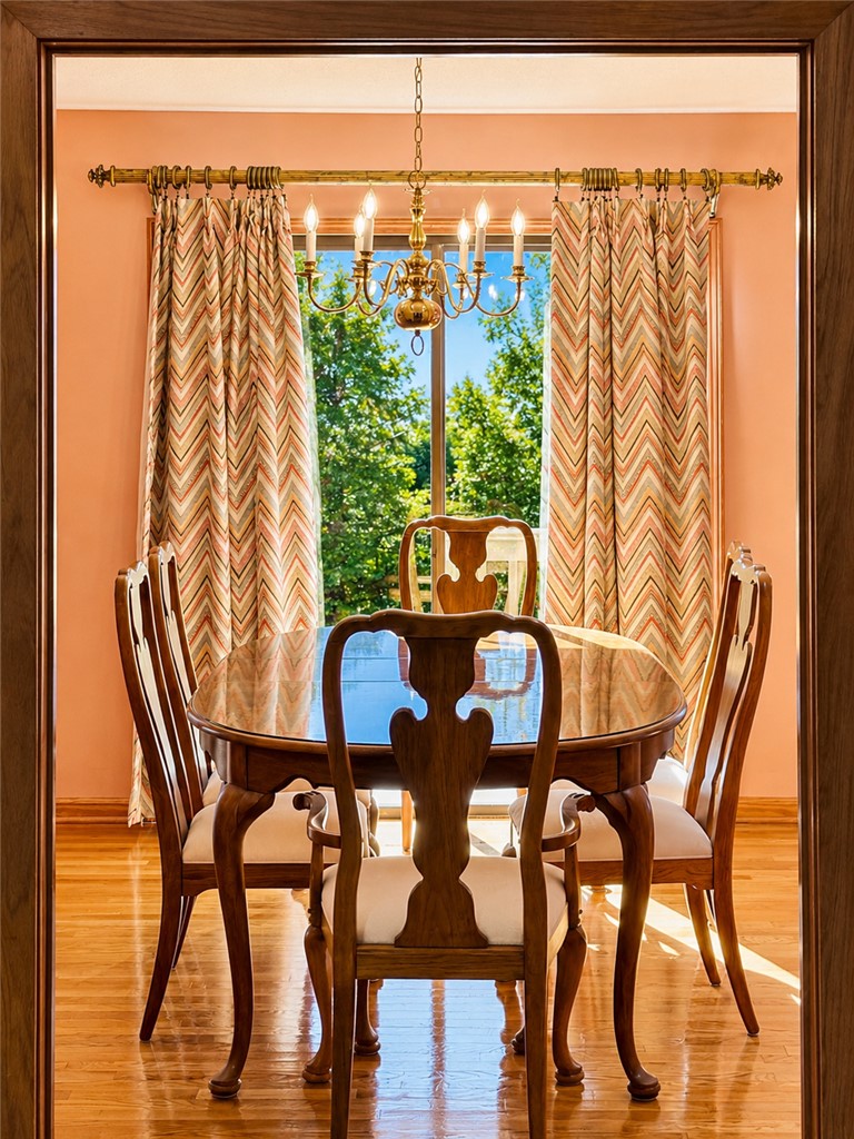 222 Terrace Drive Anderson, SC 29621 - Photo 11 of 37 A refined dining room with lustrous hardwood floors and a striking chandelier, overlooking lush greenery.