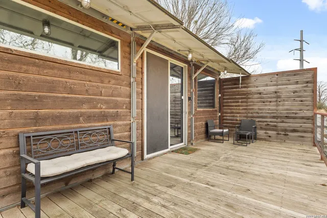 a living room with stainless steel appliances furniture and a flat screen tv