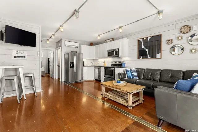a living room with furniture a flat screen tv and a large window