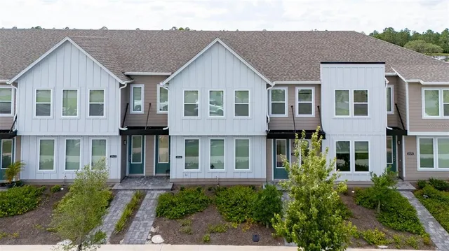 a view of a white house next to a yard