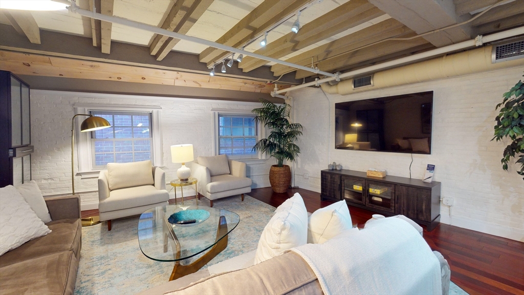 15 Union Street, Unit 4 Boston, MA 02108 - Photo 1 of 18 a living room with furniture a flat screen tv and a chandelier