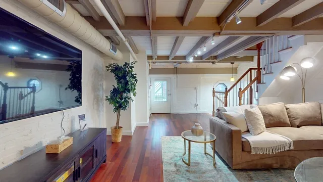 a living room with furniture and wooden floor
