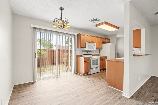 a kitchen view with stainless steel appliances wooden floor and a refrigerator