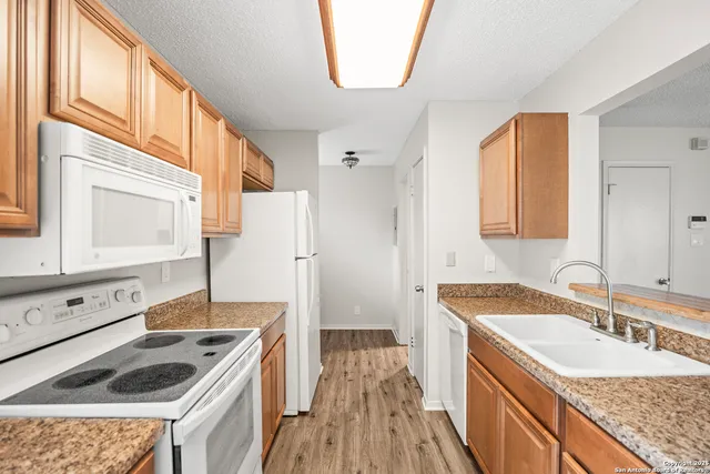 a kitchen with granite countertop a sink stove and cabinets