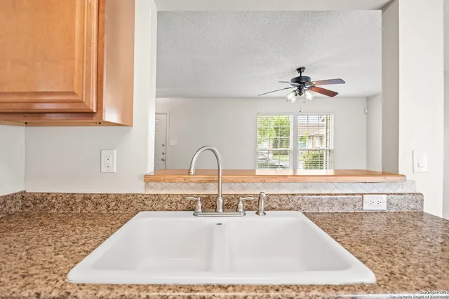 a kitchen with a sink a window and cabinets