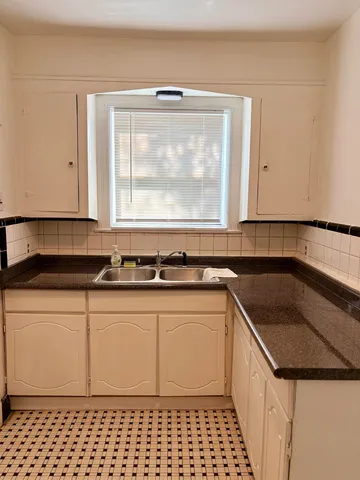 a kitchen with a sink a window and cabinets