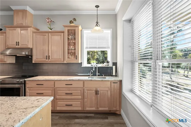 a kitchen with granite countertop a sink and a stove
