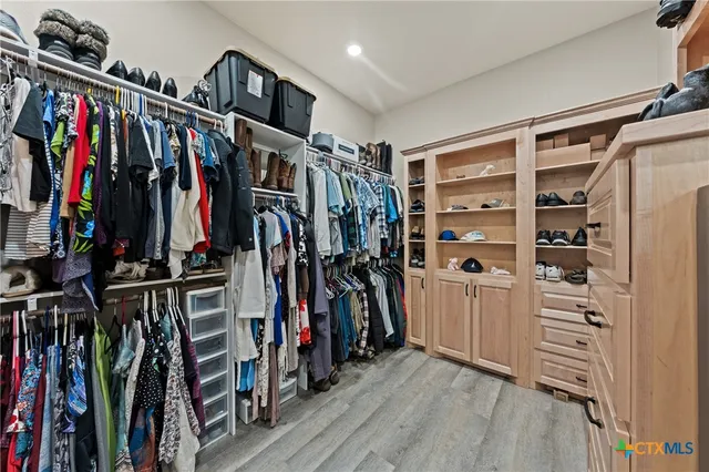 a view of walk in closet with clothes