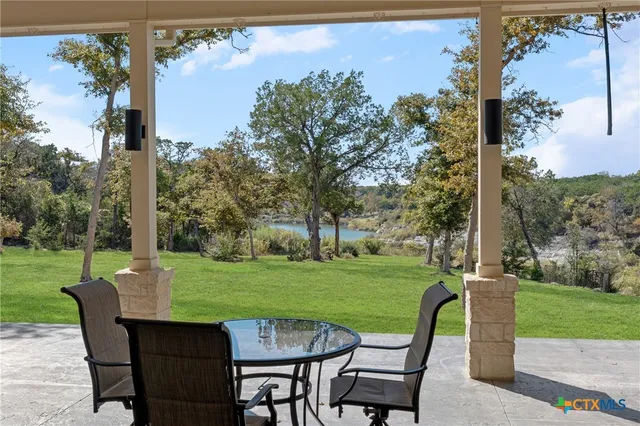 a view of a wooden dinning table and chairs in the garden