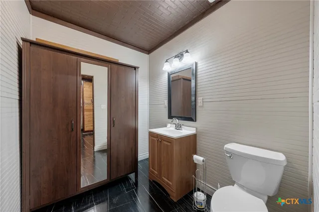 a white toilet sitting next to a bathroom sink