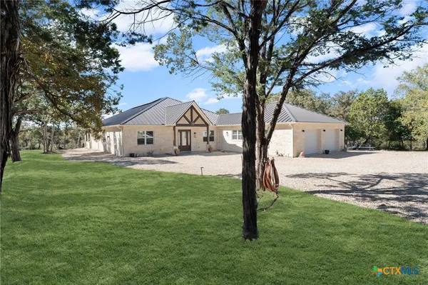 a white house that has a tree in front of a house