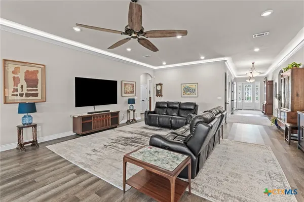 a kitchen with granite countertop a stove a sink dishwasher and white cabinets with wooden floor