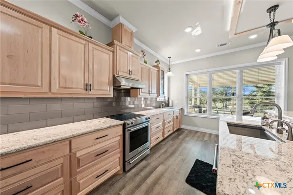 a kitchen with granite countertop a sink and a stove