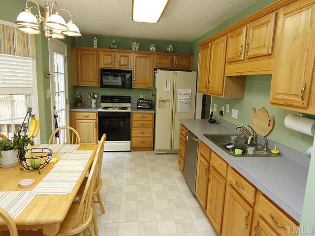 2504 Bulmer Terrace Raleigh, NC 27615 - Photo 4 of 12 a kitchen with stainless steel appliances granite countertop a sink dishwasher stove and refrigerator with wooden floor