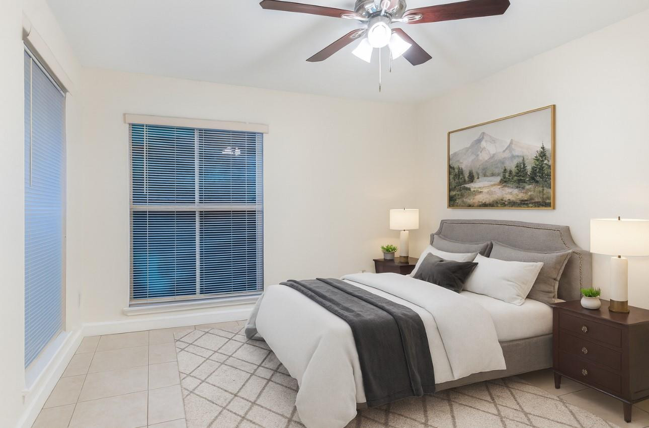 875 Riverside Drive, Unit 717 Coral Springs, FL 33071 - Photo 12 of 31 a bedroom with a large bed and a chandelier