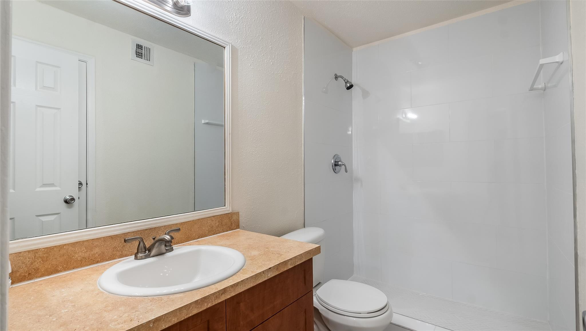 875 Riverside Drive, Unit 717 Coral Springs, FL 33071 - Photo 18 of 31 a bathroom with a granite countertop sink toilet a mirror and shower