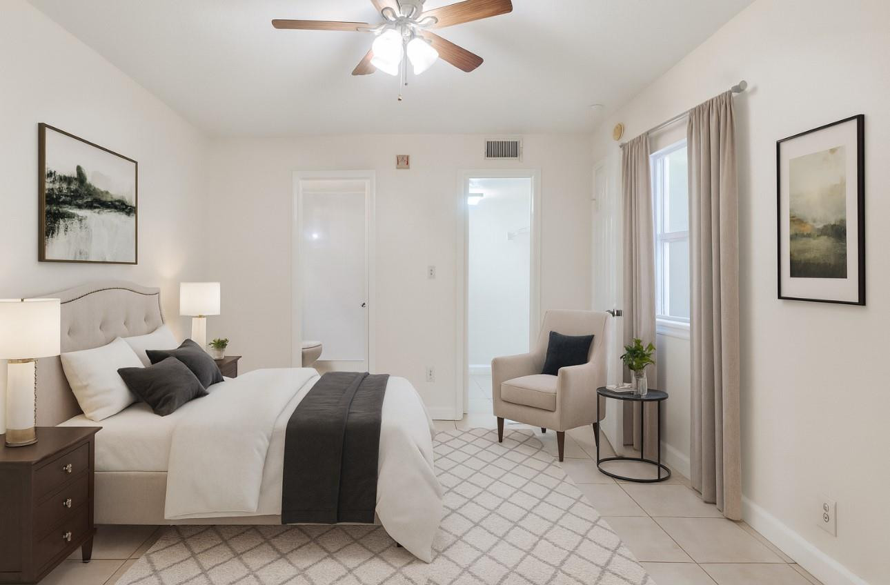 875 Riverside Drive, Unit 717 Coral Springs, FL 33071 - Photo 10 of 31 a bedroom with a bed and a chandelier