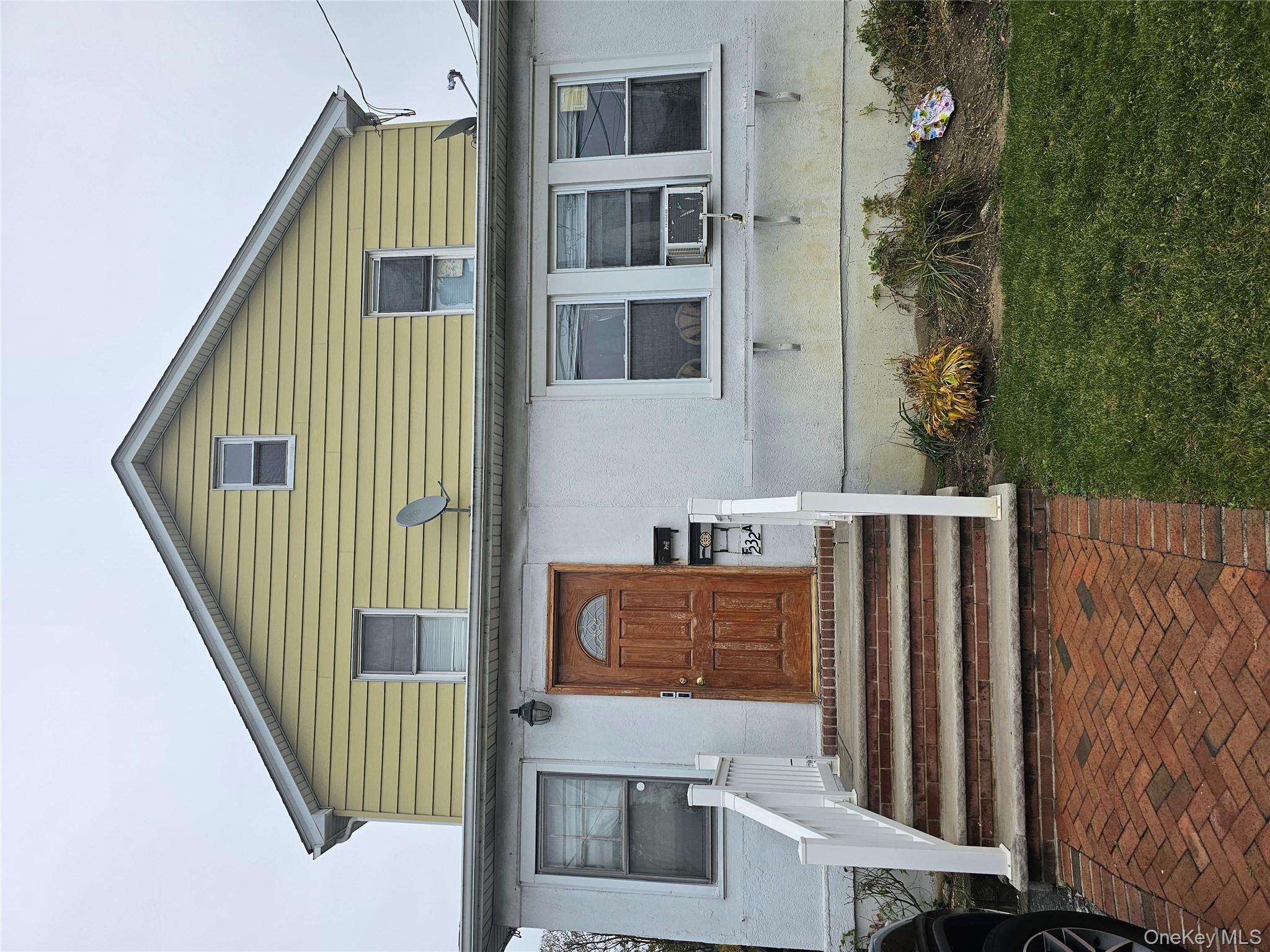 232 Doughty Boulevard Inwood, NY 11096 - Photo 1 of 11 a front view of a house with a yard